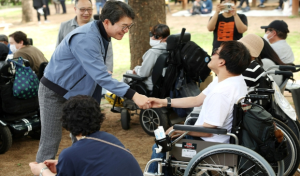 정원오 성동구청장(사진 왼쪽)이 장애인의 날 기념행사(4. 26.)에서 주민과 반갑게 인사를 나누고 있다.