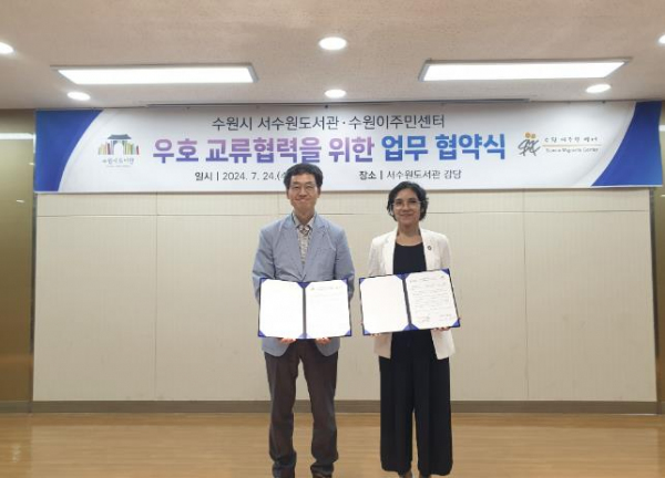 최강구 호매실도서관 관장(왼쪽), 마킨 메이타 수원이주민센터 대표(오른쪽)가 업무협약 후 기념촬영을 하고 있다.