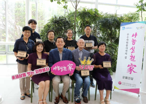 이재준(앞줄 왼쪽에서 2번째) 수원시장과 우수자원봉사자들이 25일 수원시청 새빛민원실에서 문패 전달식을 가진 뒤 기념촬영을 하고 있다.