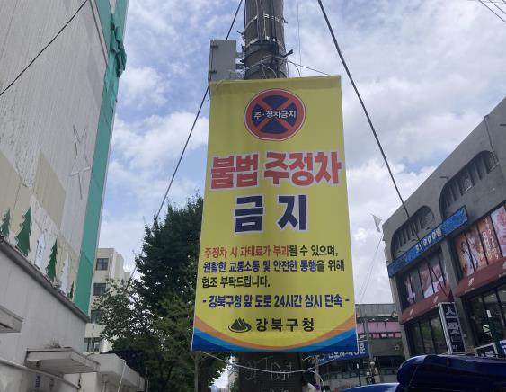강북구 보행특화거리 한천로139길 구간에 불법 주·정차 집중단속 현수막이 걸려 있다.